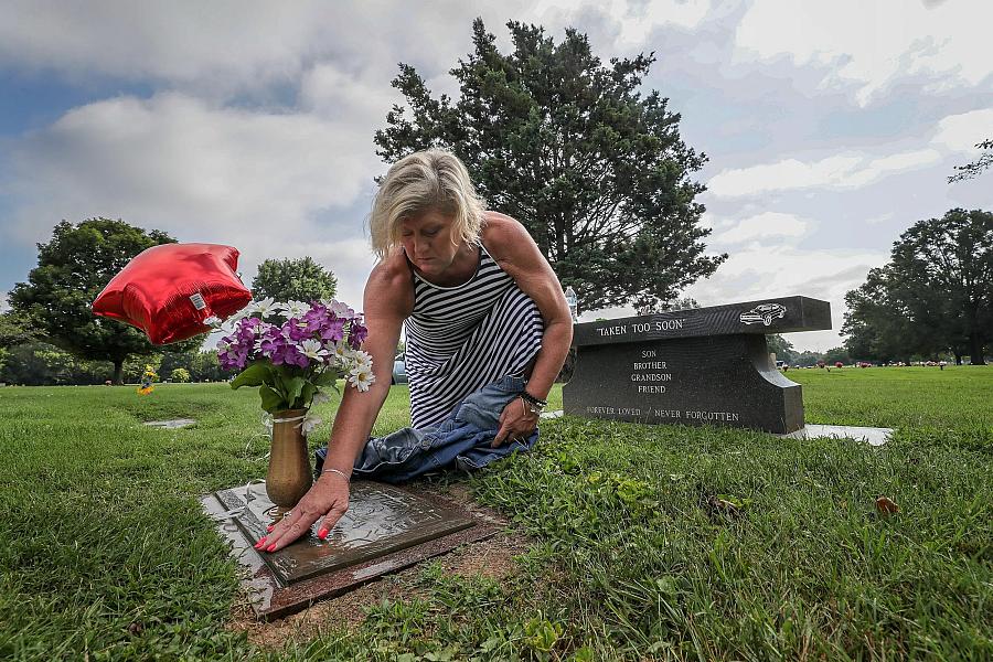 Mother with balloons on her son's grave