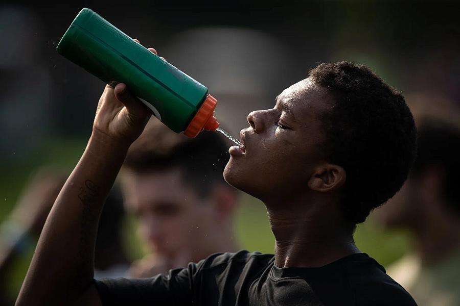 Player drinking water from green bottle