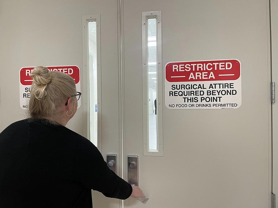 Person holding a door with restricted sign on it