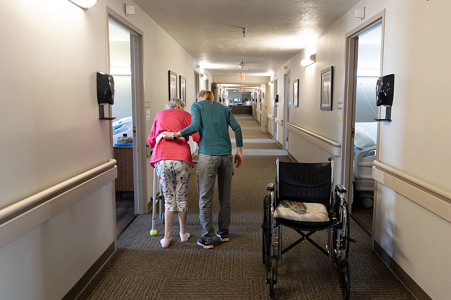 Person supporting elderly person while walking