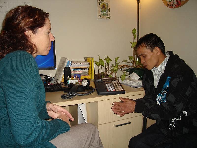 Terapeuta Julanne Bibro-Ruch trabaja con Adu Sit, un refugiado birmano, en el Centro de Salud de Squirrel Hill. Un intérprete participa por teléfono. (Erika Beras/Reporting on Health Collaborative)