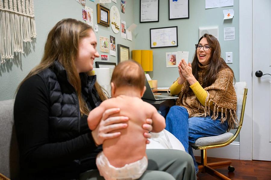 Two people in a clinic, one with an infant