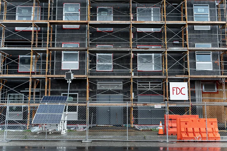 Building under construction with scaffolding and solar panels.