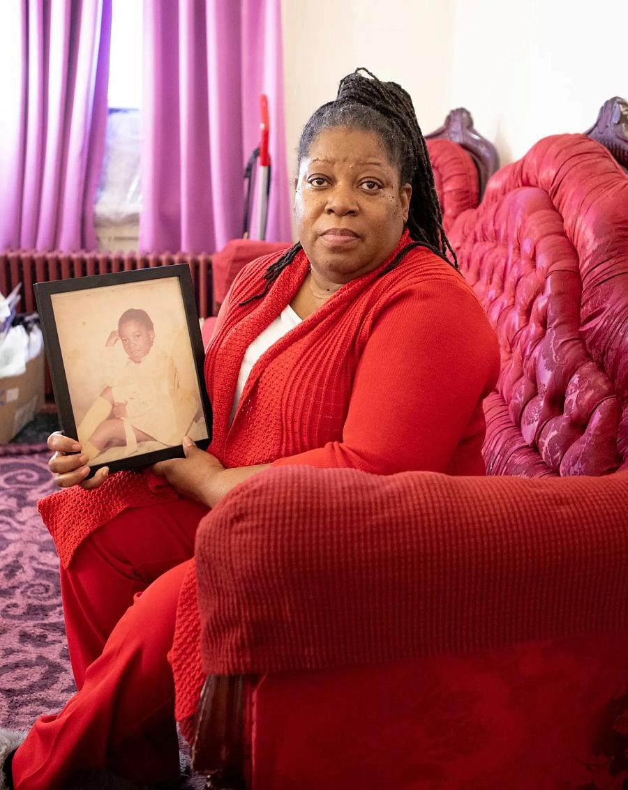 Cherry DeJesus holds a framed photo of herself as a little girl in her New Jersey home on Feb. 26, 2023. (Chantel Philip/Word In Black)