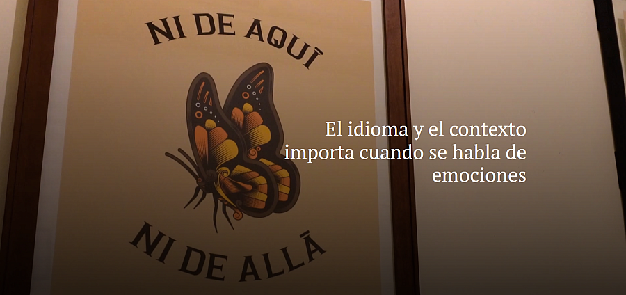 Wall art showing a butterfly with the phrase “Ni de aquí, ni de allá” (“Neither from here nor there”), alongside the text “El idioma y el contexto importa cuando se habla de emociones” (“Language and context matter when talking about emotions”).
