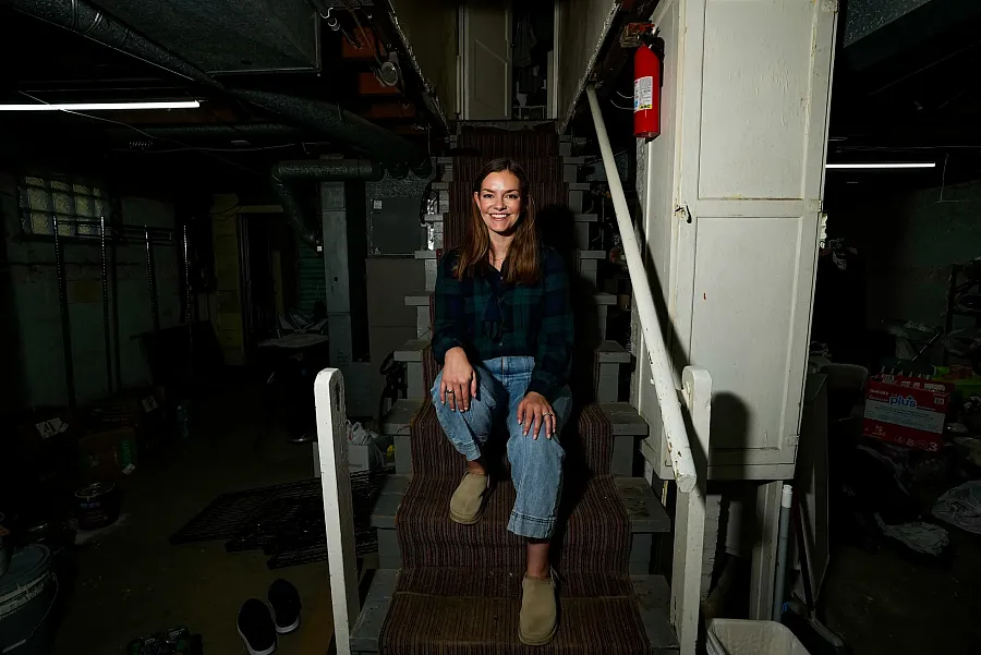 A person sitting on stairs in a basement