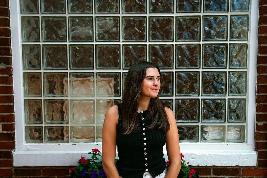 A person in black dress against a window