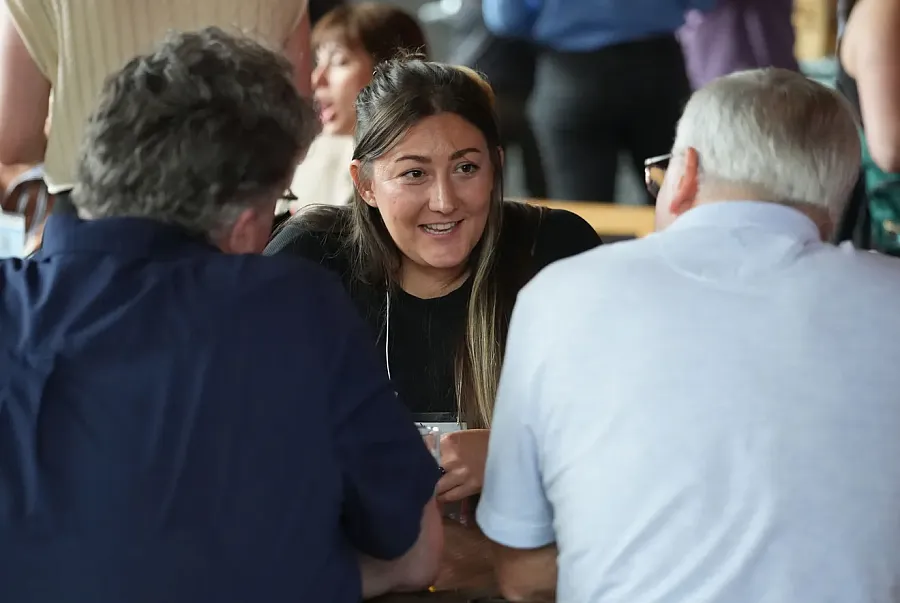 A person talking with two other people at a table