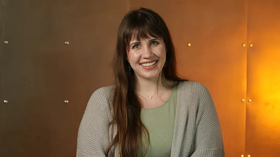 A person in green top with gray coat