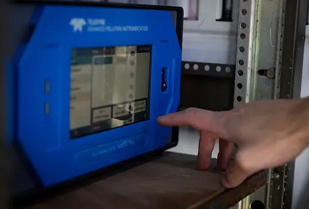 Person pointing at a blue color monitor