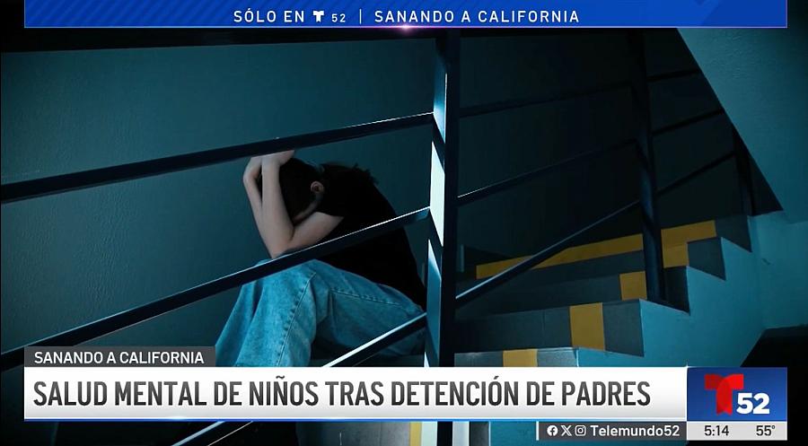 A person sitting on staircase with head tucked in their hands