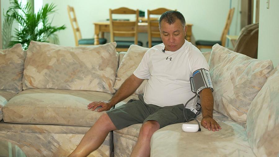 A person sitting on a sofa, checking blood pressure