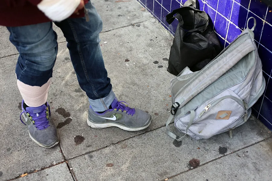 two bags and a person standing next to them on the road 