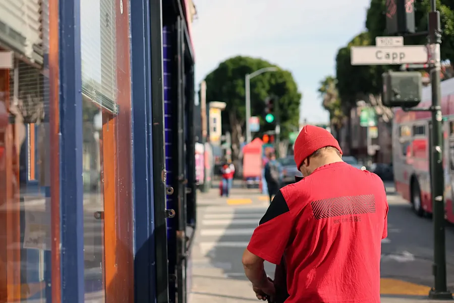 A person wearing red shirt walking on the street 