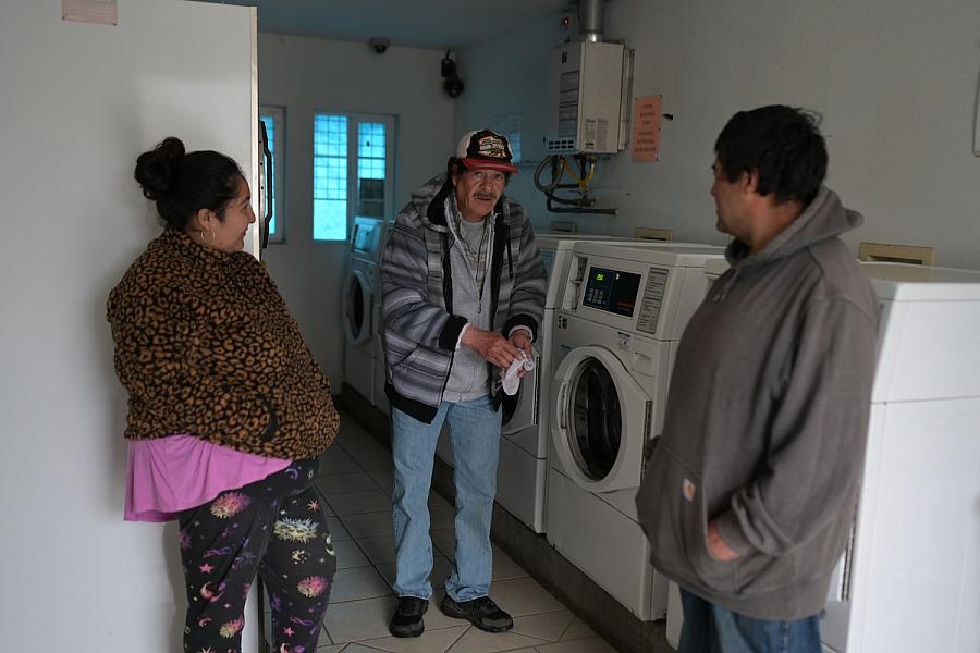 People standing by laundry machines