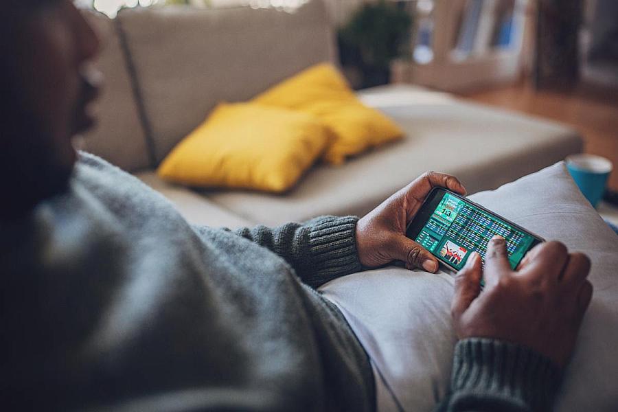 Person holding a mobile phone with a game betting screen on