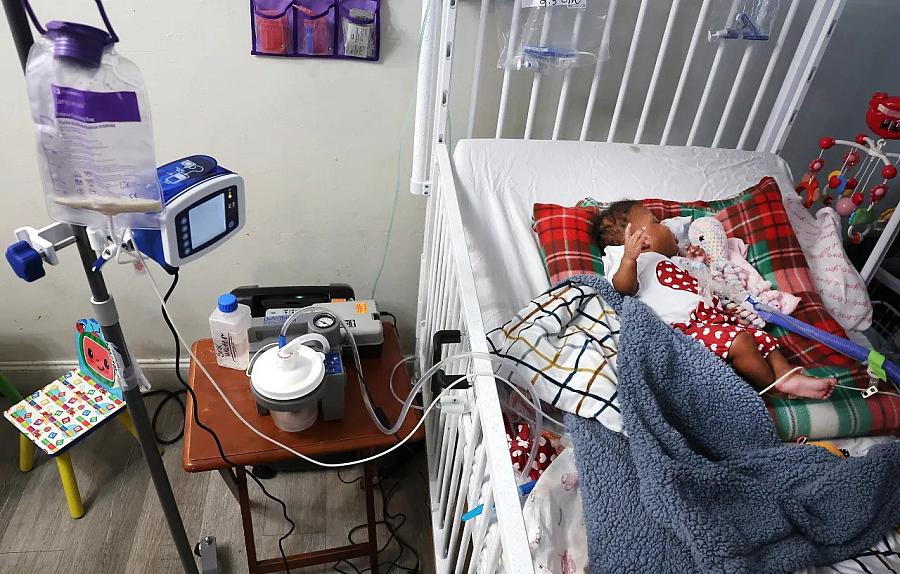 Image of a baby in a crib hooked up to life-saving machines