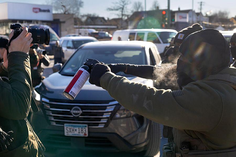 A person brandishing a spray upon journalists