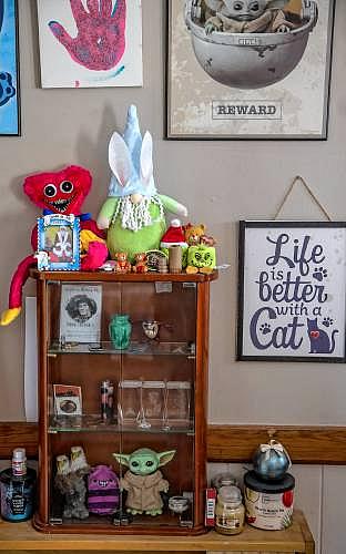 Shelf with toys, figures, and framed signs.