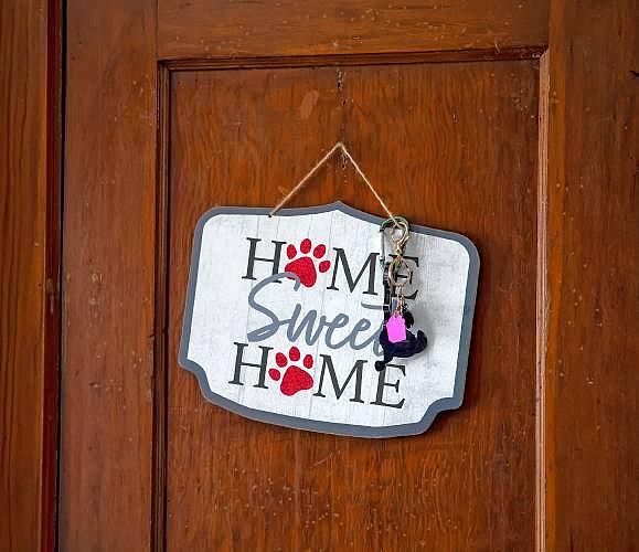 “Home Sweet Home” sign with keys on a wooden door.
