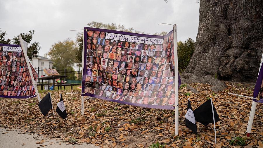 A sign displays the images of people who died from fatal opioid overdoses in Mississippi