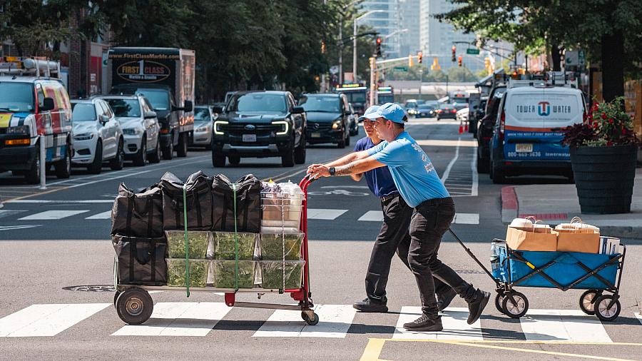 Person crossing the road with a cart
