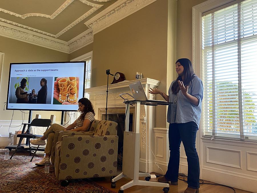 Two reporters speak to a room full of journalists about their reporting projects.