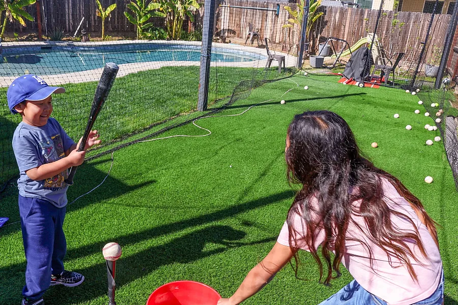 A child and adult playing baseball