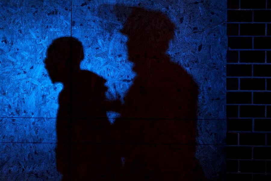 An image of shadow of two people on blue background.