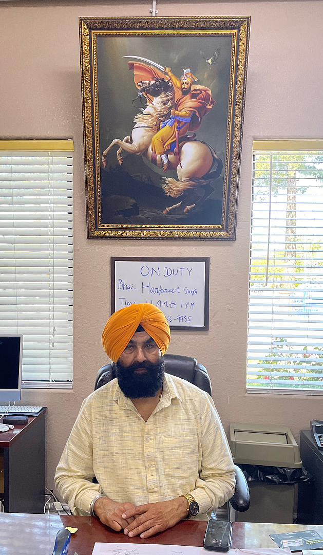 Person in orange turban sitting on a chair