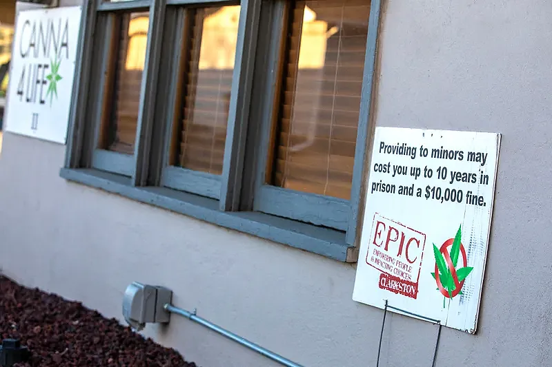 A sign with a warning about the penalties adults could face if they purchase cannabis for minors is posted outside Canna4Life Cannabis Dispensary in Clarkston. Prosecutions under the law are infrequent. 