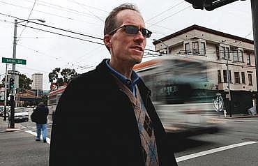 John Alex Lowell, vice chairman of the city's Pedestrian Safety Advisory Committee, at Mission and 14th streets, where he was severely injured while jogging nearly 10 years ago.