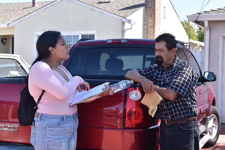 Nataly Mendoza, a student at Sequoia High School in Redwood City, conducts an interview in Spanish with a man.