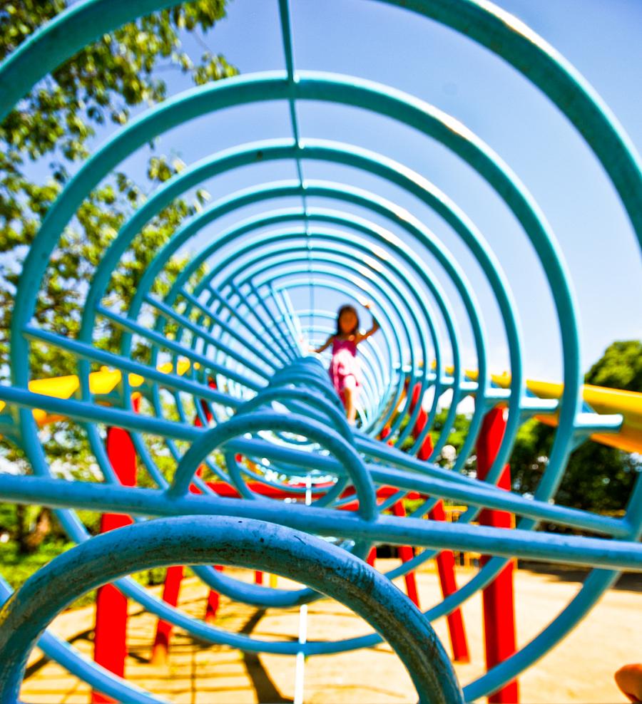 This is a photo of a child in a playground jungle gym.