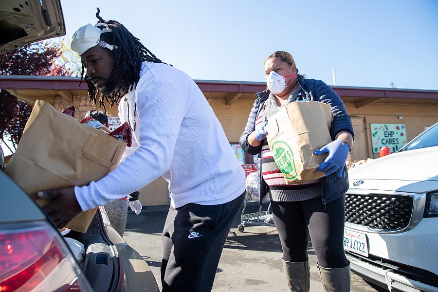 Will Preston and Lene Lauese, staff members at Ecumenical Hunger Program, put bags of produce in a client's car at drive thru set up by the nonprofit in East Palo Alto earlier this year, providing critical food aid to struggling households. Will Preston and Lene Lauese, staff members at Ecumenical Hunger Program, put bags of produce in a client's car at drive thr