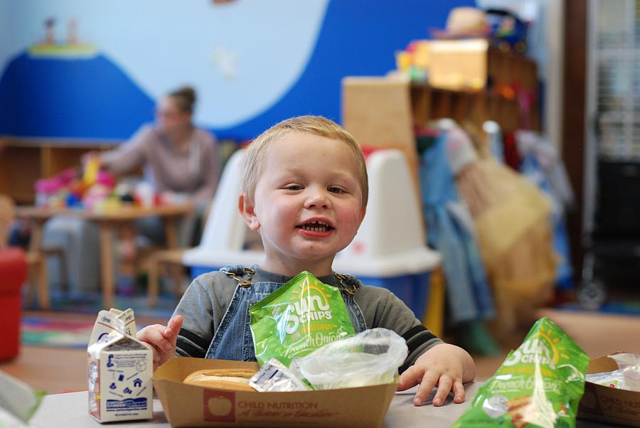 Two-year-old Jesse Bryson enjoys a bag of Sun Chips during the Seamless Summer Food program at the Family Resource Center of the