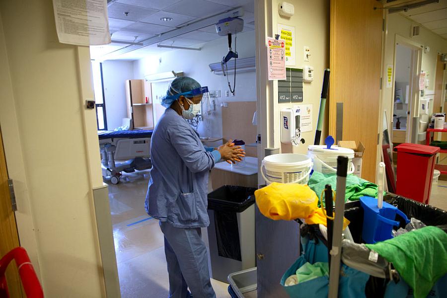 A member of housecleaning services disinfects her hands after cleaning a room in a COVID-19 unit at a Seattle hospital last year