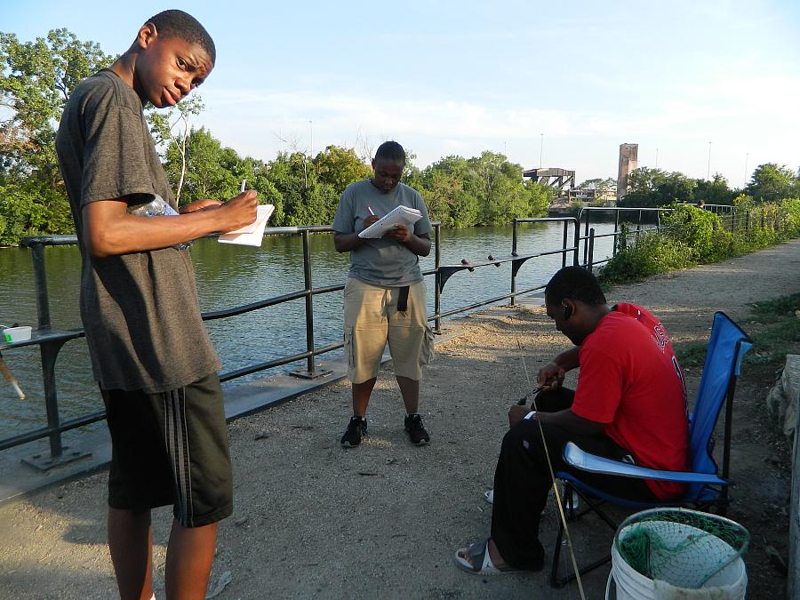 PHOTO: Jaylen Miller and Tyreshia Black (center) interviewing fishermen on the Chicago River, Courtesy of Kari Lydersen