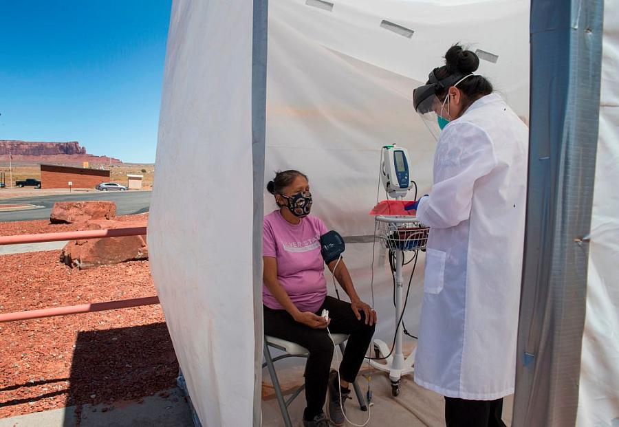 A nurse checks vitals on a Navajo woman complaining of virus symptoms at a COVID-19 testing center in Monument Valley, Arizona i