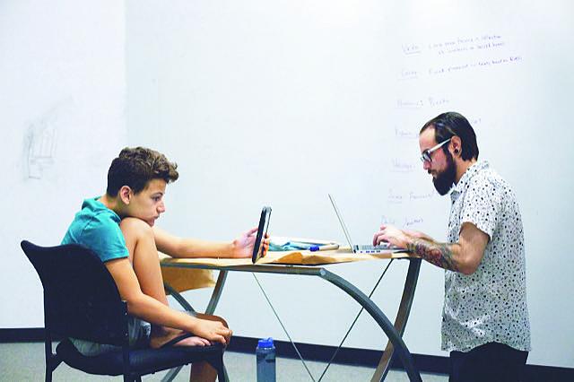 Dominic Maciel studies with his social studies teacher Michael Ponce at Halstrom Academy in Cupertino, Calif. Photo by Magali Ga