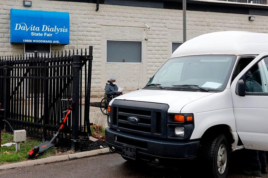 Dialysis clinic, with patient waiting by van.