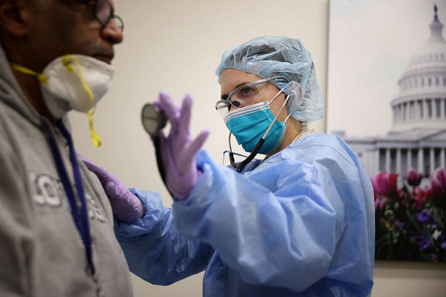 A nurse practitioner examines a patient.