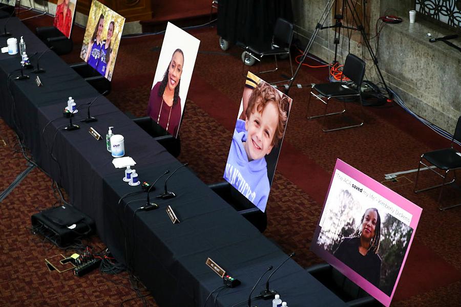 Pictures of people helped by the Affordable Care Act occupy the seats of Democratic senators boycotting a Senate Judiciary Commi