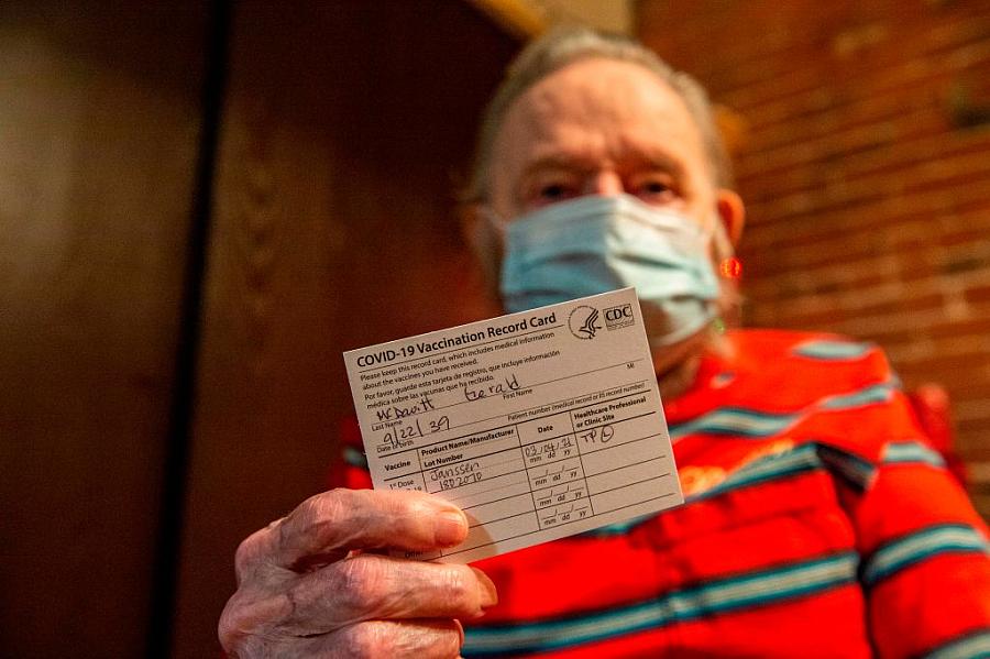 Gerald McDavitt, 81, a Veteran of the United States Army Corps of Engineers, holds his CDC vaccine card after being inoculated 