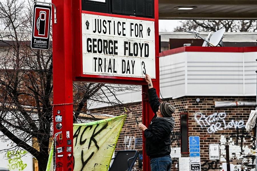 A man changes the number of a sign board at a makeshift memorial of George Floyd before the third day of jury selection begins i