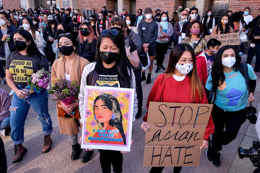 Demonstrators wearing face masks and holding signs take part in a rally to raise awareness of anti-Asian violence 
