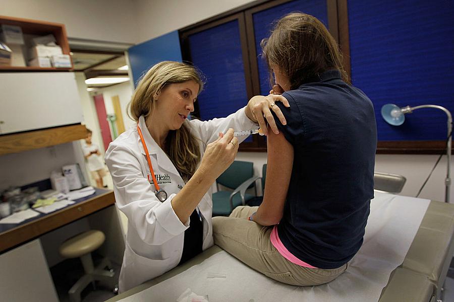 Pediatrician Judith L. Schaechter gives an HPV vaccination to a 13-year-old girl in her office at the Miller School of Medicine 