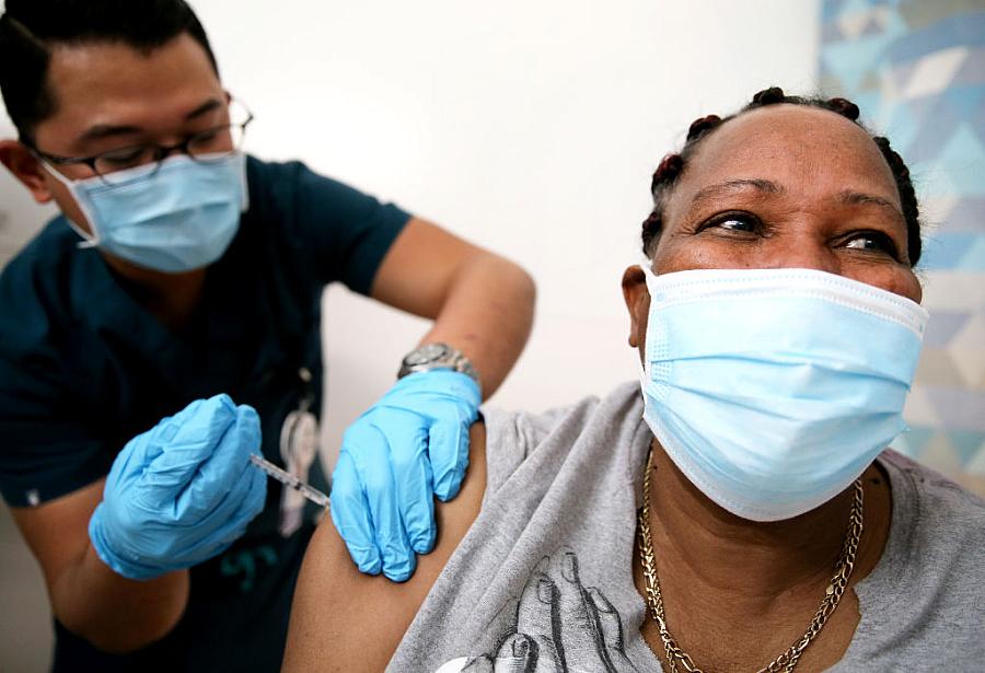  Lorraine Harvey, an in-home care worker, receives her first dose of the COVID-19 vaccine