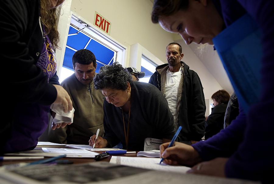 Attendees at a health insurance enrollment fair in Richmond, California, fill out paperwork. (Photo by Justin Sullivan/Getty Images) Attendees at a health insurance enrollment fair in Richmond, California fill out paperwork. (Photo by Justin Sullivan/Getty Imag