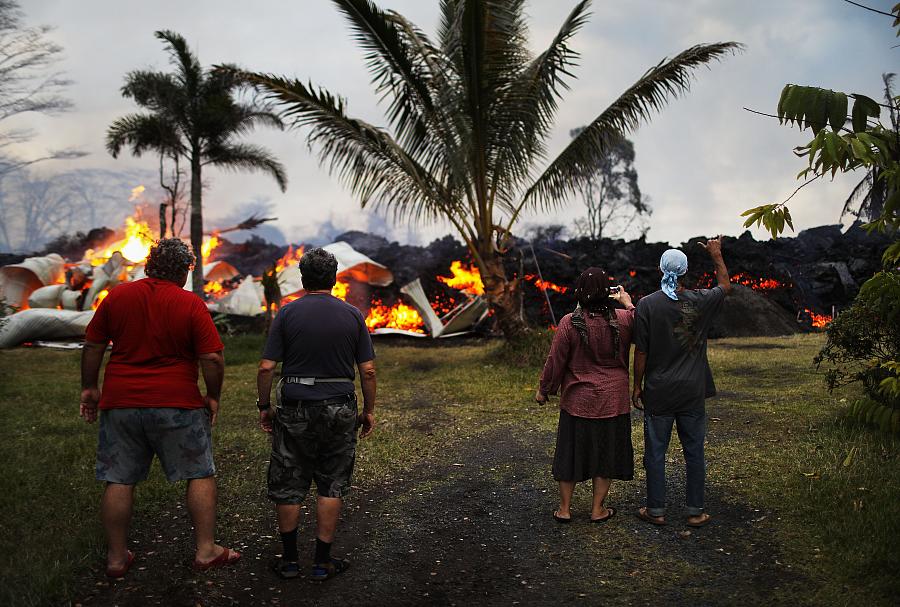 Community members watch as a home is destroyed by lava from a Kilauea volcano fissure in Leilani Estates, on Hawaii's Big Island